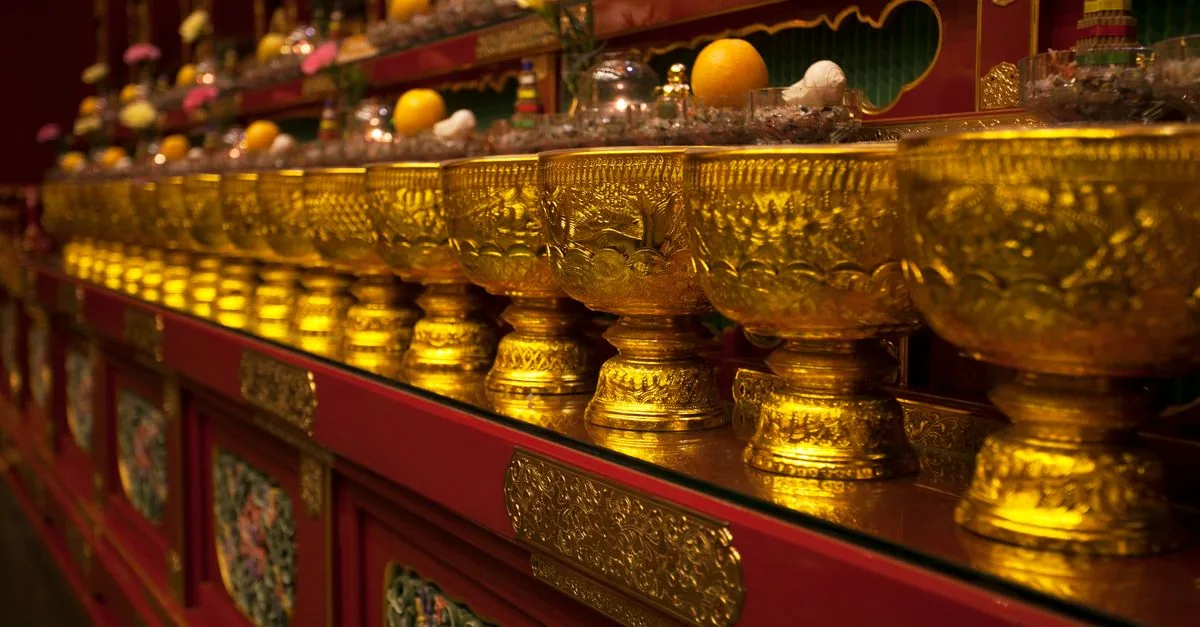 仏壇の前で花立と茶湯器と仏飯器の位置を整える様子