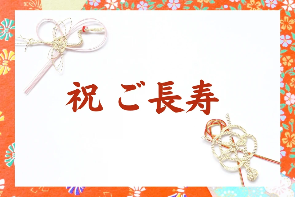 喜寿と傘寿を祝う家族が紫と黄色の贈り物を囲む様子