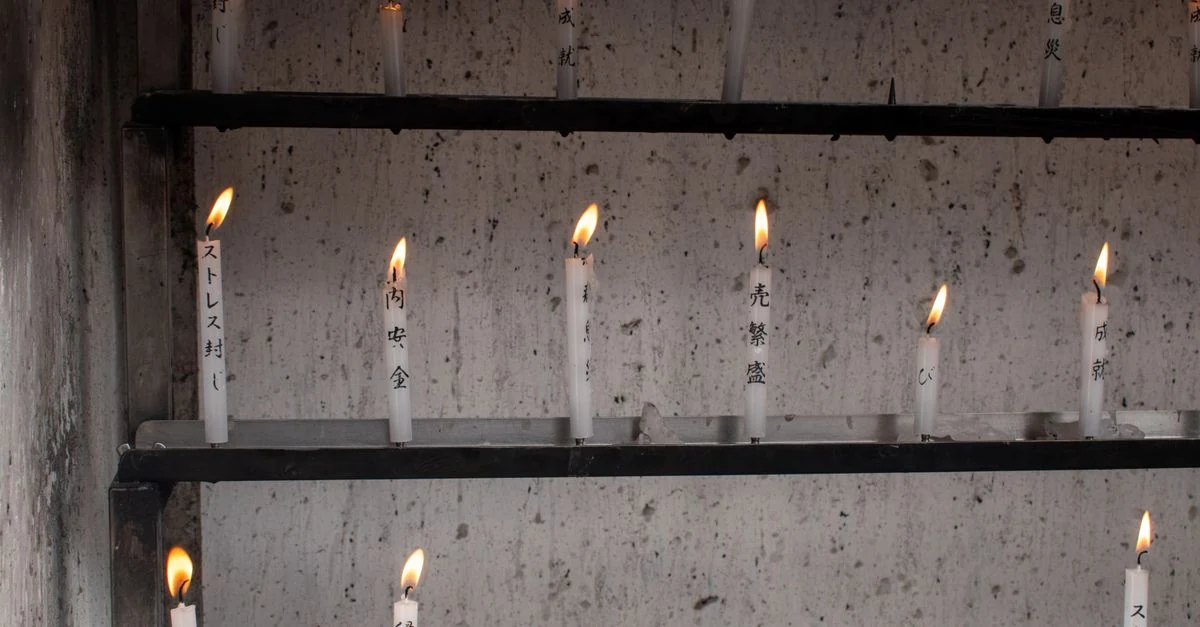 仏壇に置く電池式LEDろうそくとリモコンを比較する様子
