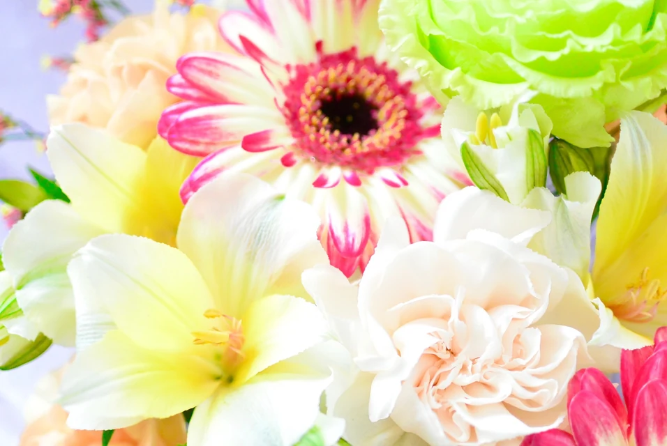 母の長寿祝いに赤や紫の花束とフラワーアレンジメントを贈る家族