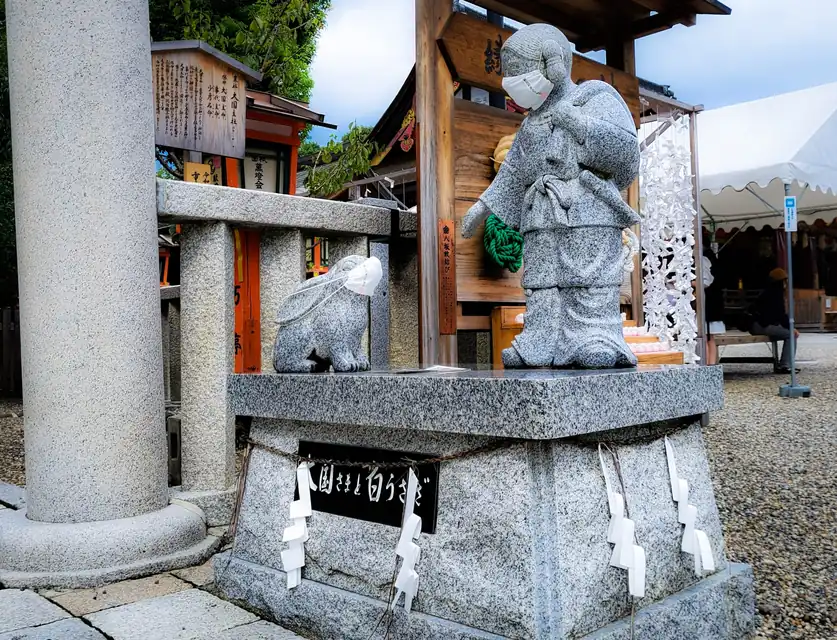旅行先の神社で受けたお神札を自宅の神棚へ丁寧に納める様子